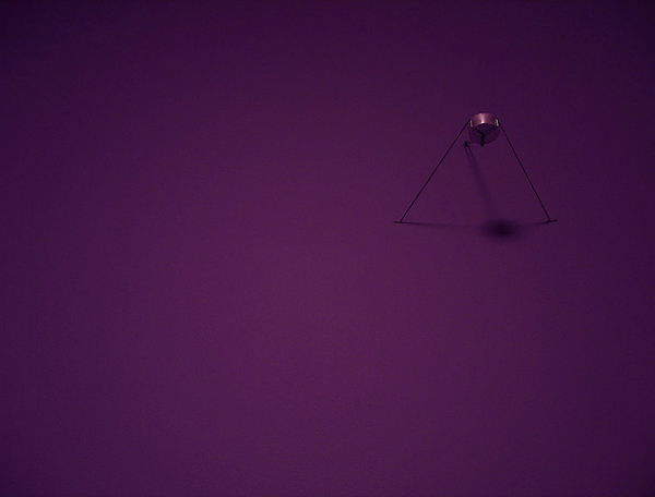 Unlit tealight on a purple wall