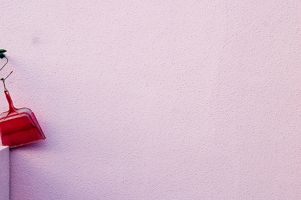 pink wall and red dust pan