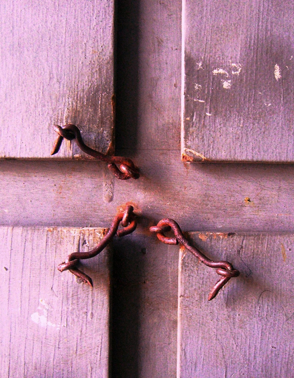 3 rusted latches on a door