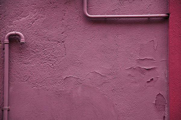 Pink wall with drain pipes showing