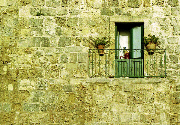 Old stone wall with green window