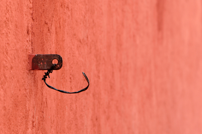 Orange wall with a makeshift metal hook