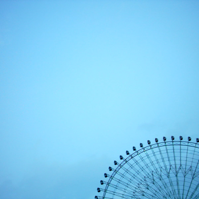 Blue sky with a partial view of the top of a ferris wheelt