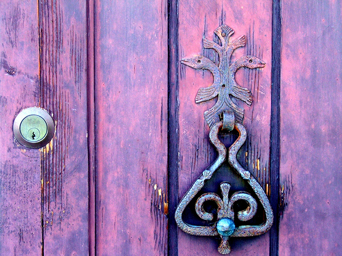 Old purple door with order door knocker and lock