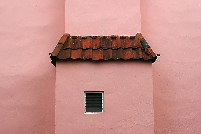 The side of pink house with tiled roof