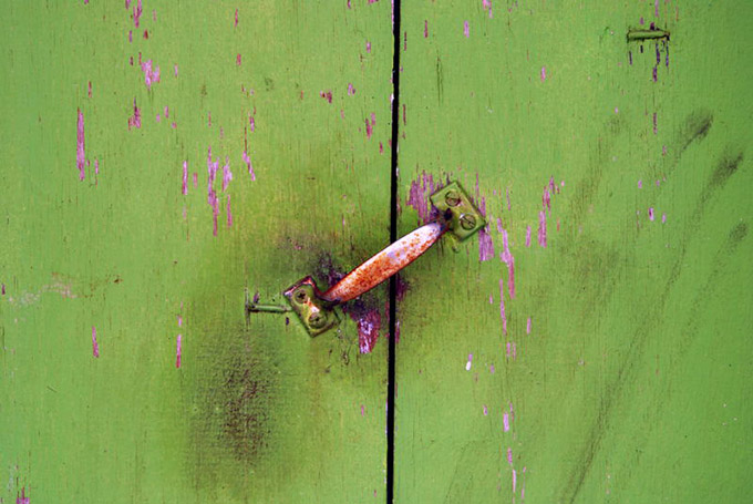 Tarnished handle on an old green painted door