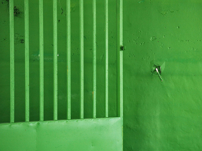 Green grill door against a green wall