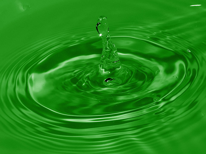 Close up of a water drop on a green background