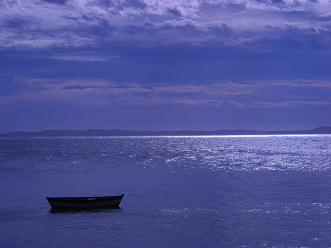 Boat on water with blue water and sky