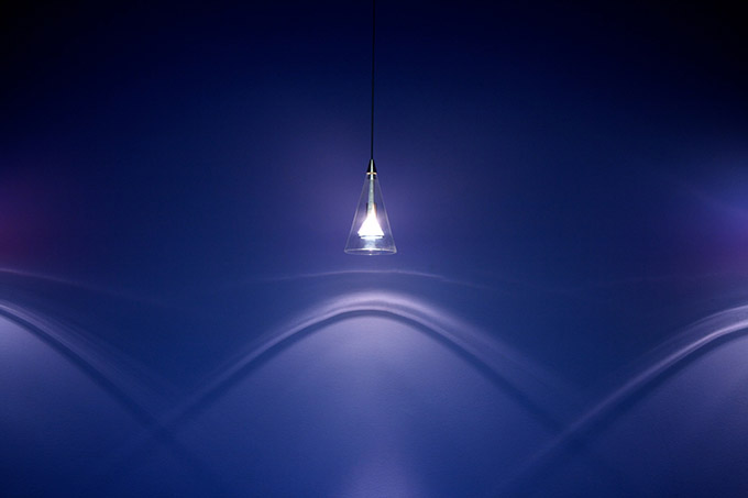 Single light casting shapes on a blue wall