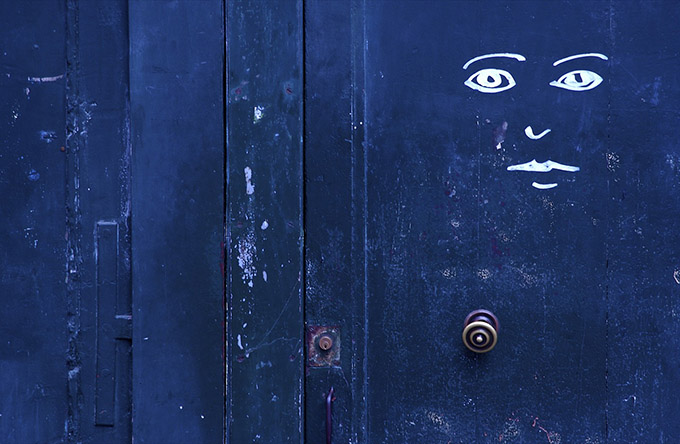 Blue door with caricature face drawn on it