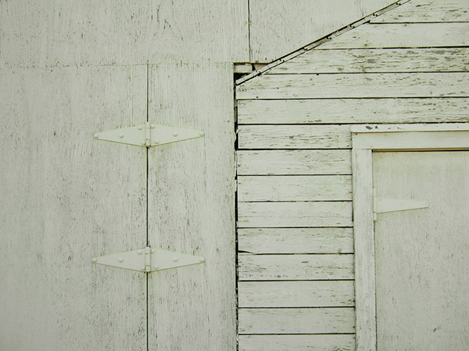 An aged white door and hinges