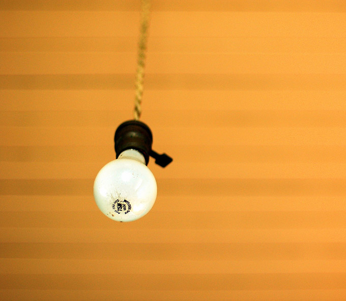 Naked bulb hanging from an orange ceiling