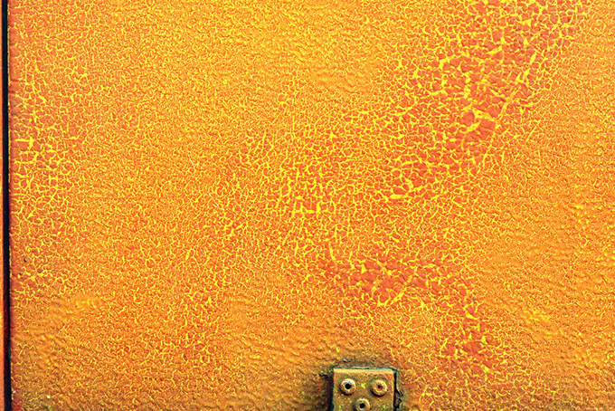 Flaking paint and rust on an orange wall