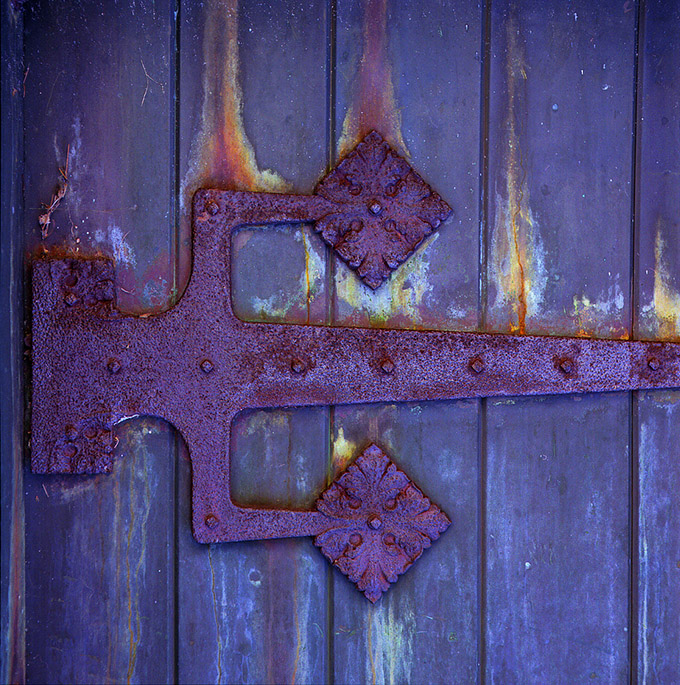 Old rusted hinge on a purple door