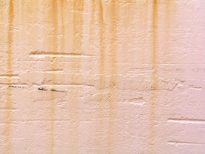 rust marks on a pale pink wall