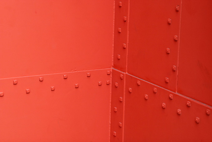 Orange metal wall with rivets